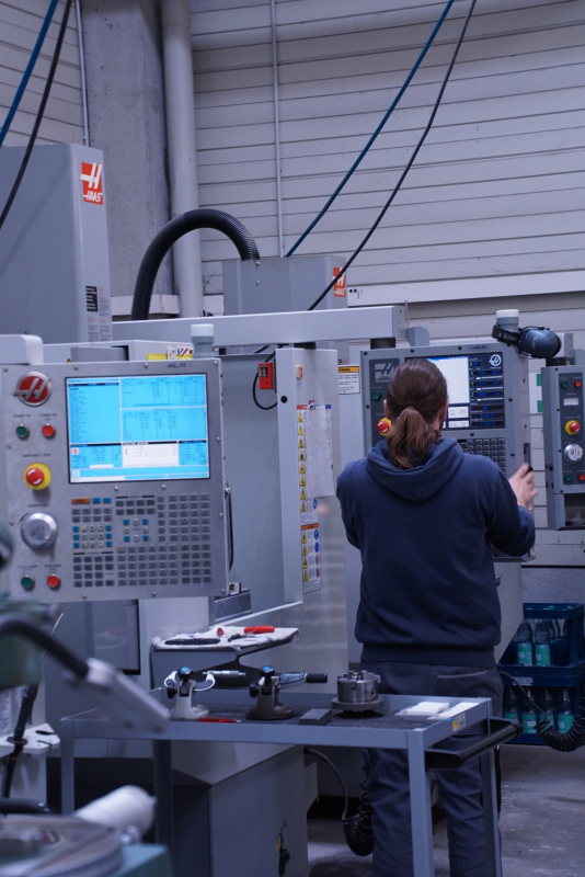 Mitarbeiter stellt CNC-Fräse für Keramik-Barbeitung im Maschinenpark ein